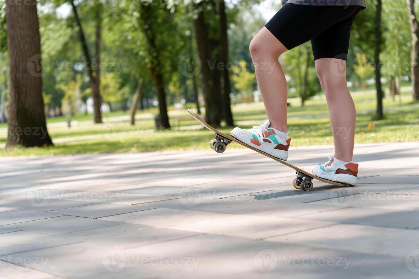 woman is feet black-colored sneakers and leggings as she performs skateboard maneuvers, representing the confident, urban lifestyle of the modern generation photo