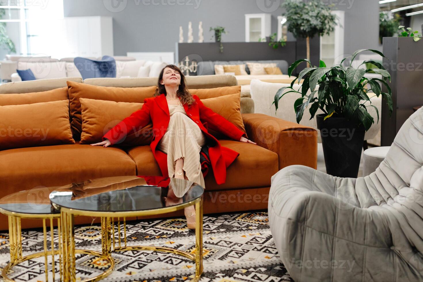 Woman relaxing on comfortable sofa in furniture store showroom. photo