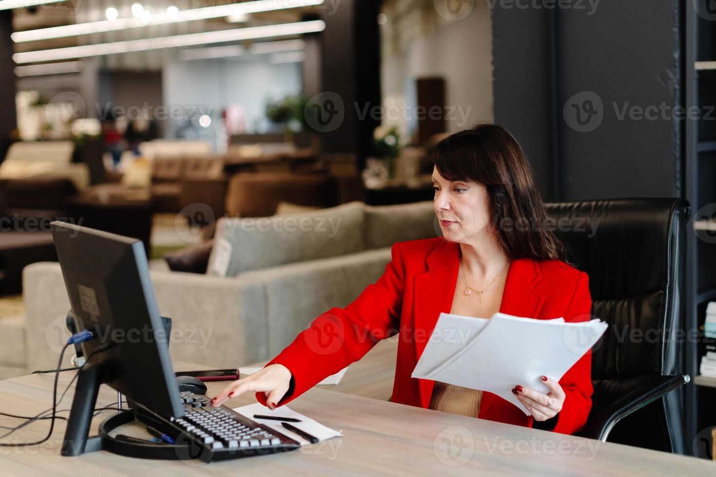 Businesswoman working with computer and documents in modern office photo