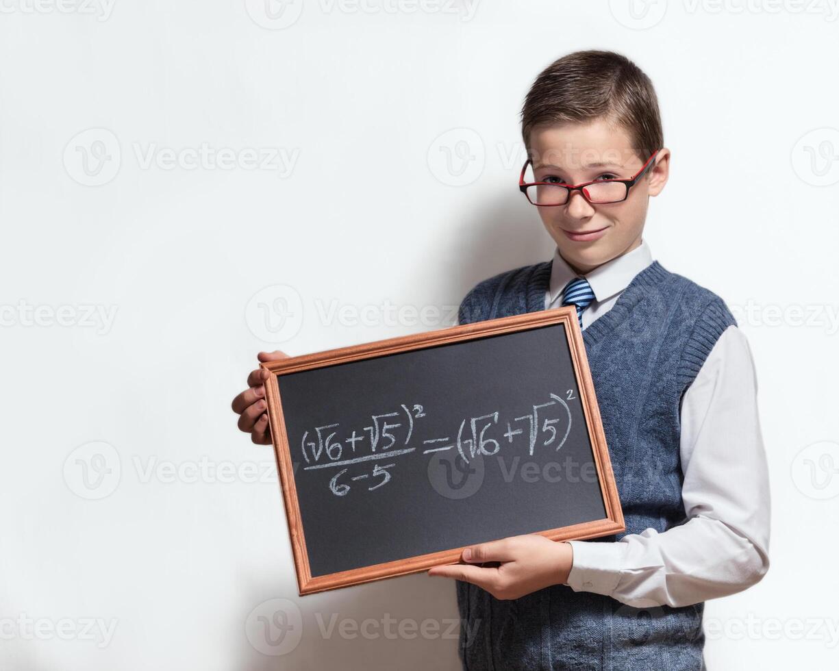 Schoolboy in glasses with mathematical equation on charcoal desk photo