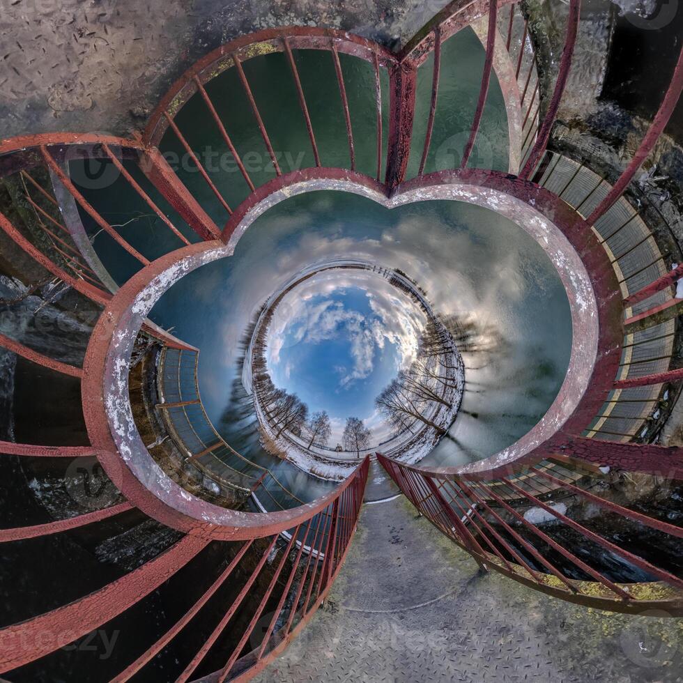 A circular view of the sky and clouds from inside a spiral staircase photo