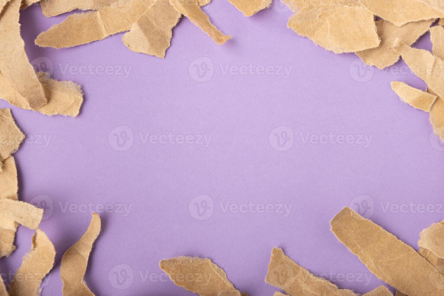 Torn kraft paper frame on purple surface background photo