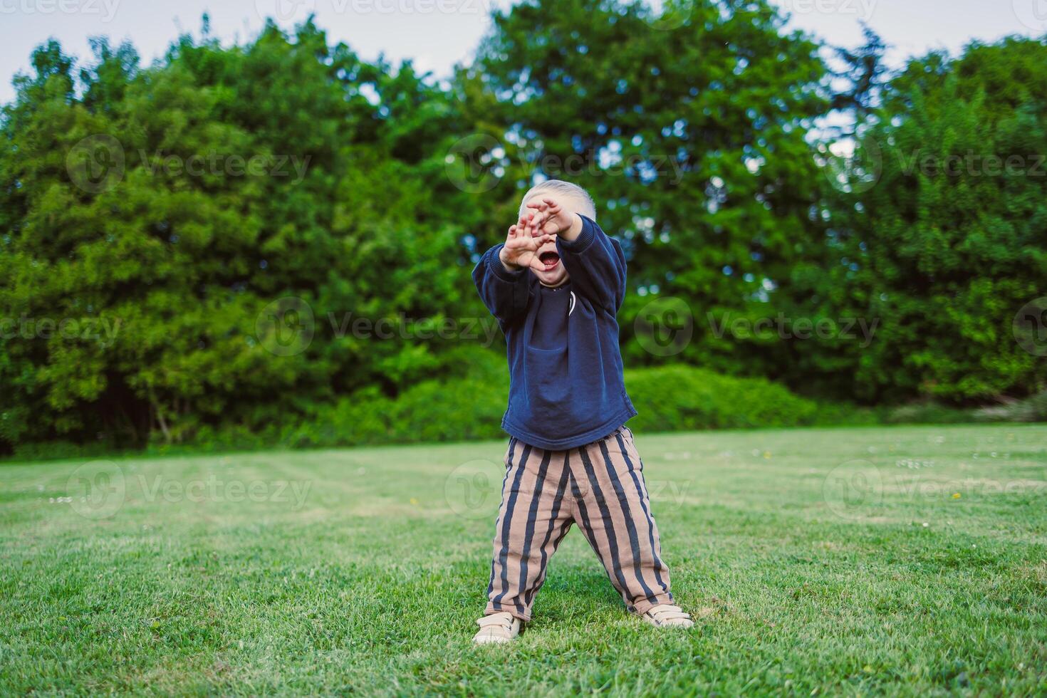 A joyful child dances freely in nature, capturing pure joy and freedom amid a lush landscape filled with life and wonder, celebrating innocent youthfulness and unbounded happiness photo