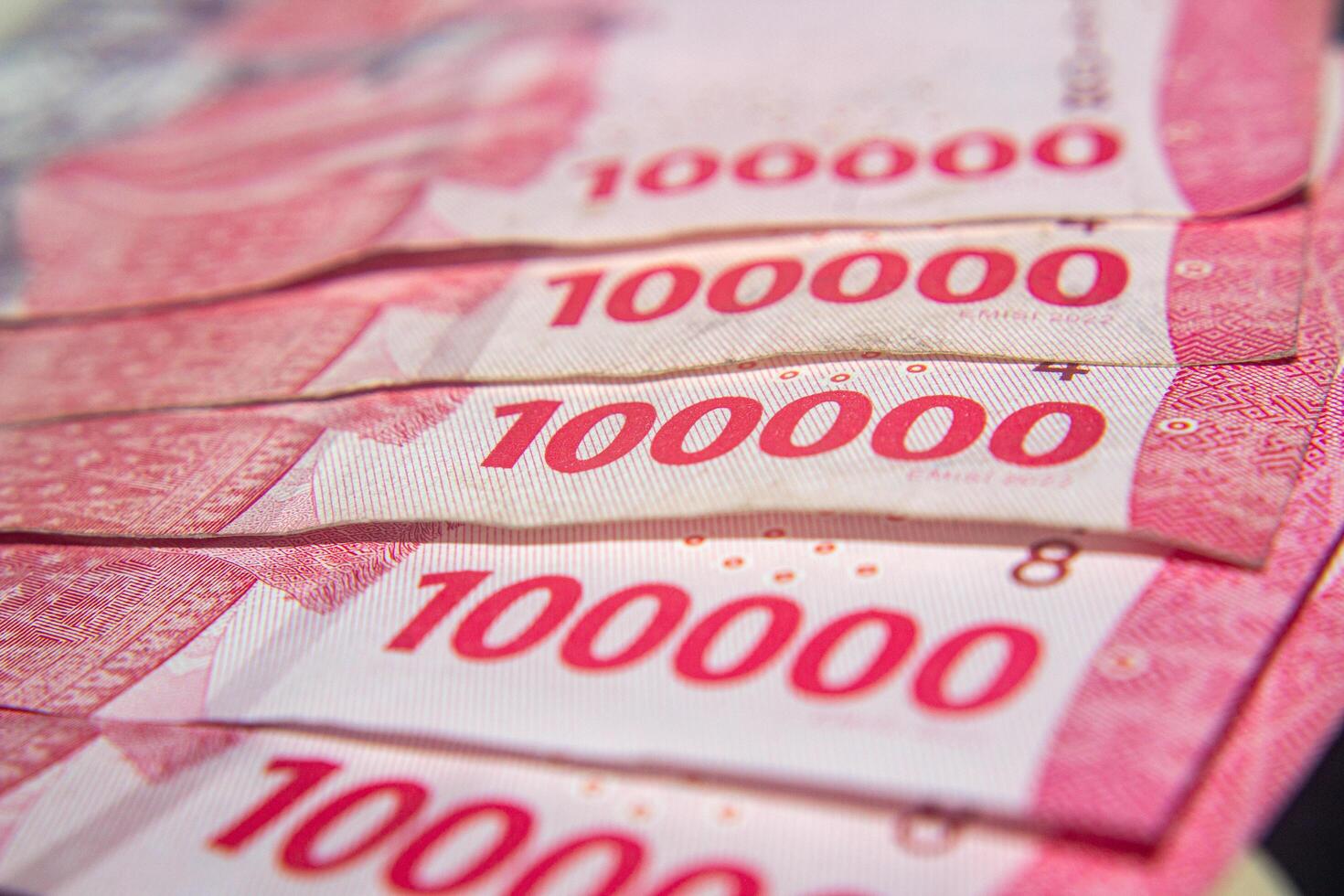 Close-up of Indonesian 100,000 Rupiah banknotes in pink tones. For business concept. photo