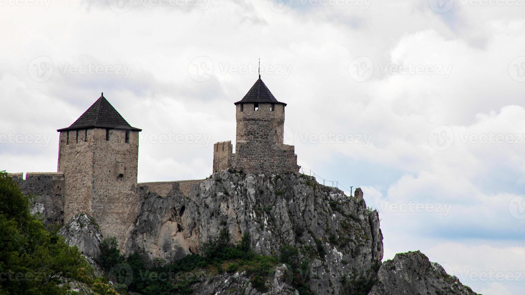 Ancient stone fortress crowns jagged cliffs under tumultuous skies, evoking medieval intrigue, fortress festivals, and historys hidden tales photo