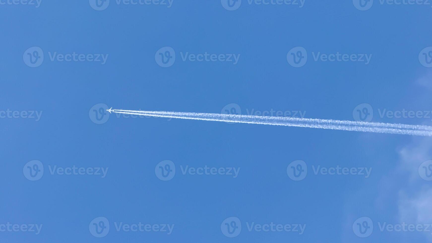 A solitary jet pierces the azure sky with whispering contrail secrets, echoing World Aviation Day and Sky Awareness Week photo
