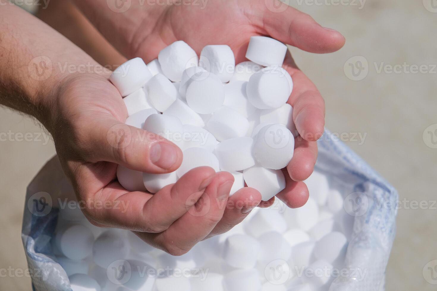 hands holding salt for cleaning the pool photo