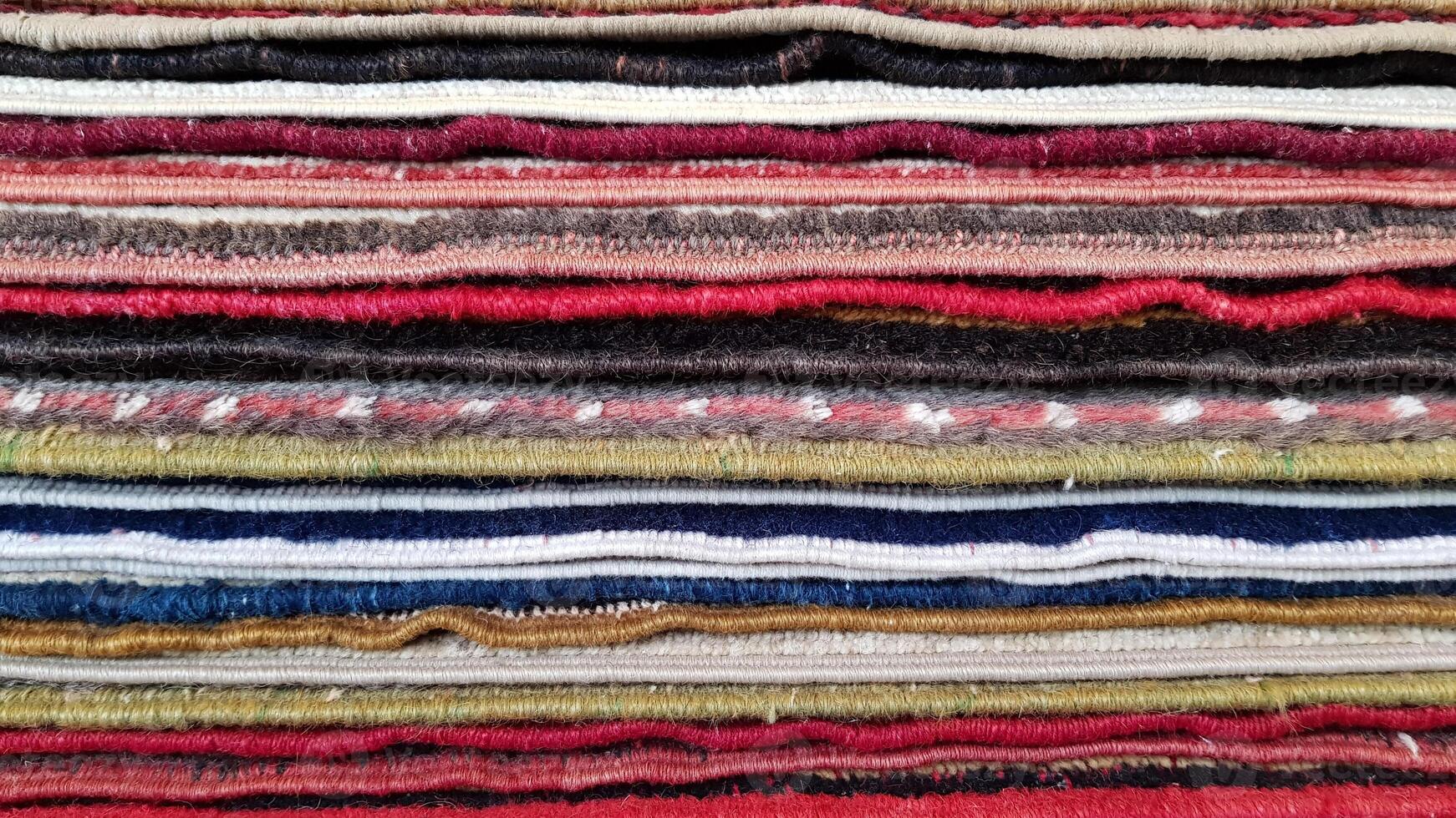Closeup of folded rugs texture. Striped pattern background photo