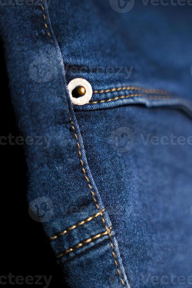 Close-Up of Button And Pocket on Blue Jeans, Detailed Denim Design photo