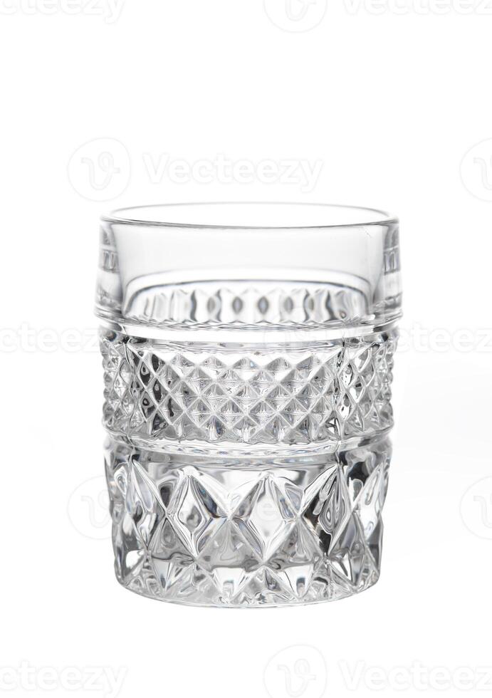 Close-up of an empty cut crystal glass with textured pattern, isolated on white background. photo