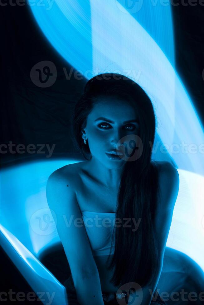Captivating portrait of a woman in blue light showcasing creative lighting techniques and artistic expression photo