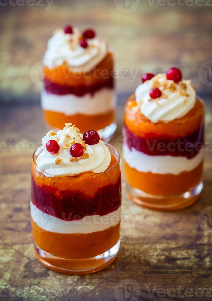 Three dessert cups with whipped cream and cranberries photo