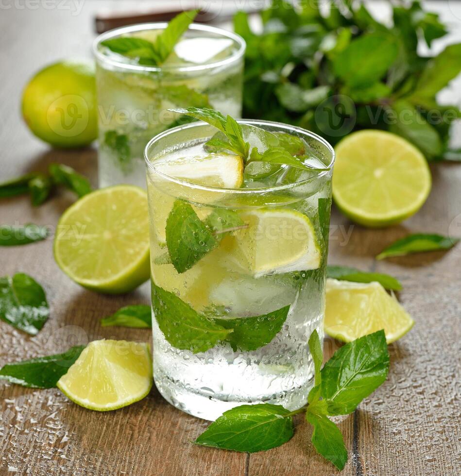Mojito in a glass with lime slices and mint leaves photo