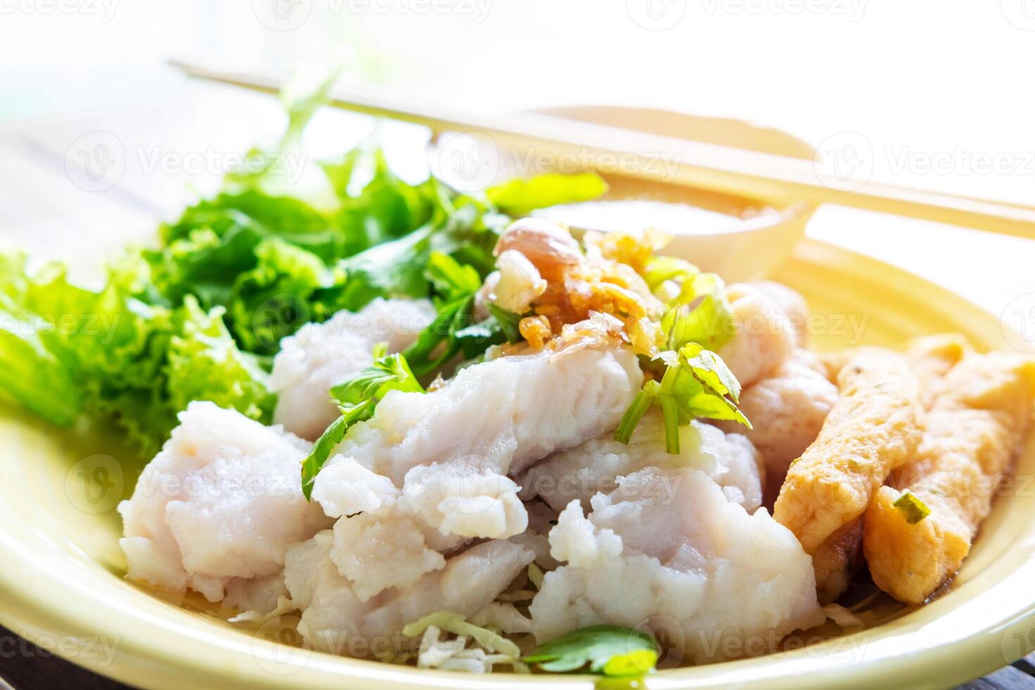 A yellow plate with fish and vegetables photo