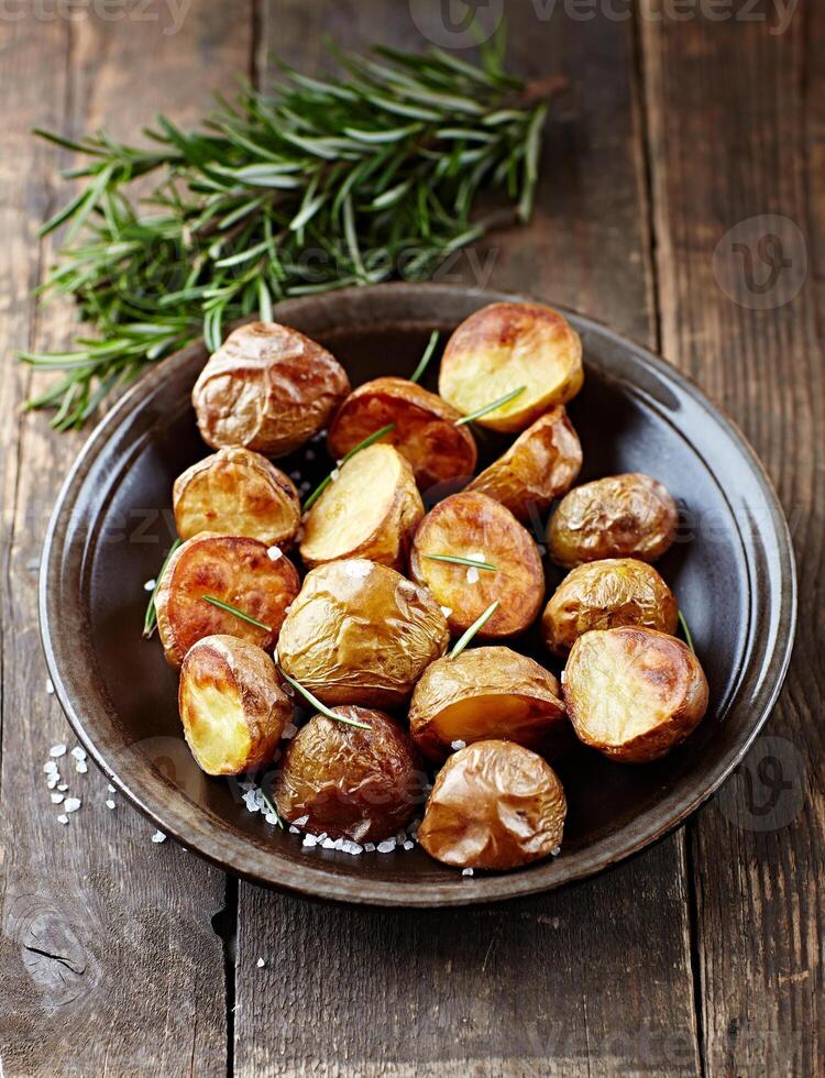 A plate of roasted potatoes with rosemary sprigs photo