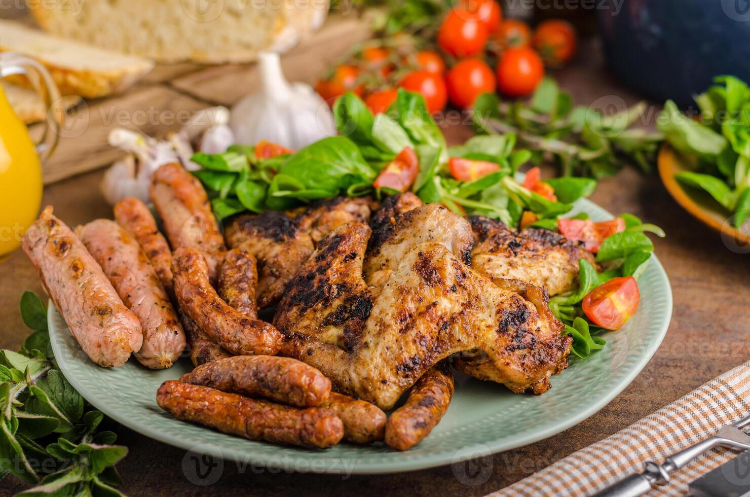 Grilled chicken, sausages and salad on a plate photo