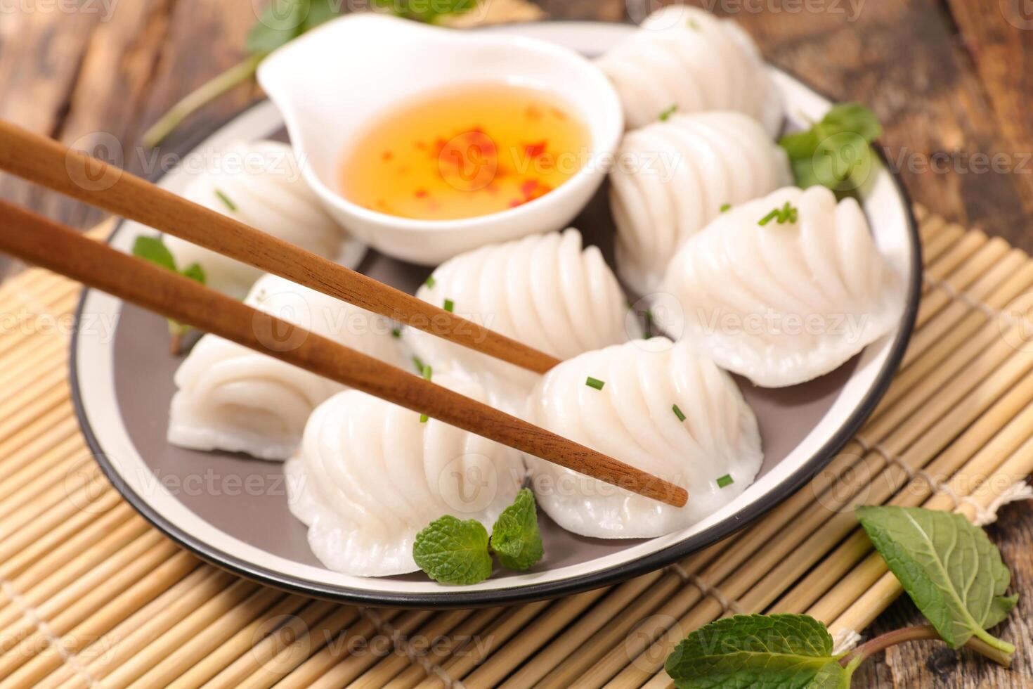 Chopsticks and dumplings on a plate with sauce photo