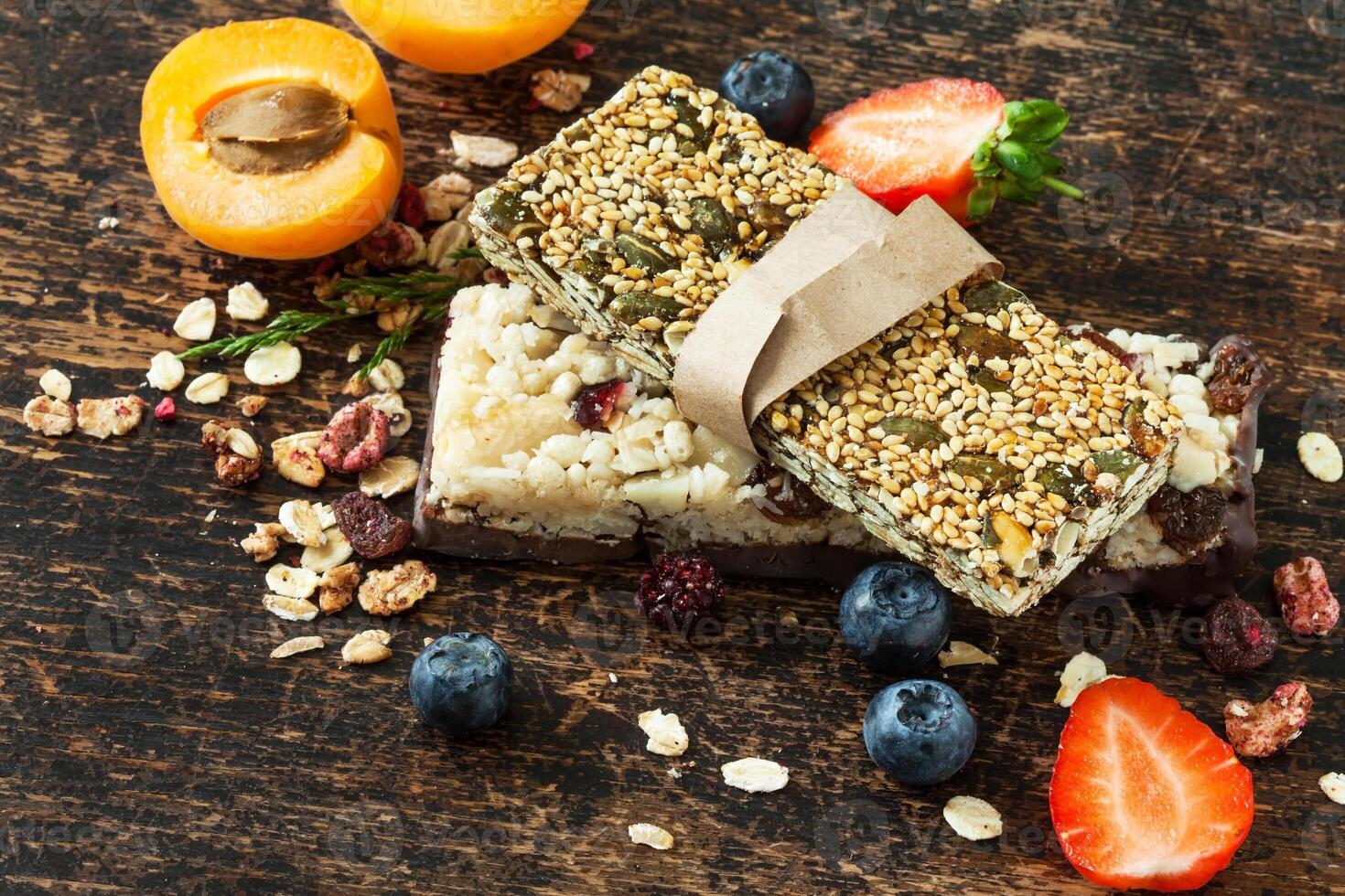 Granola bars with fruit and nuts on a wooden table photo