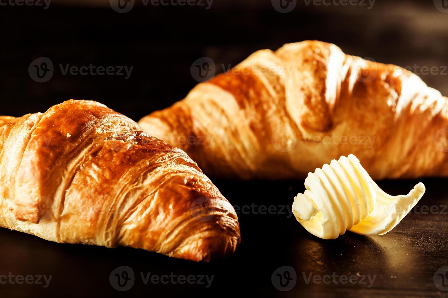Two croissants sit next to butter photo