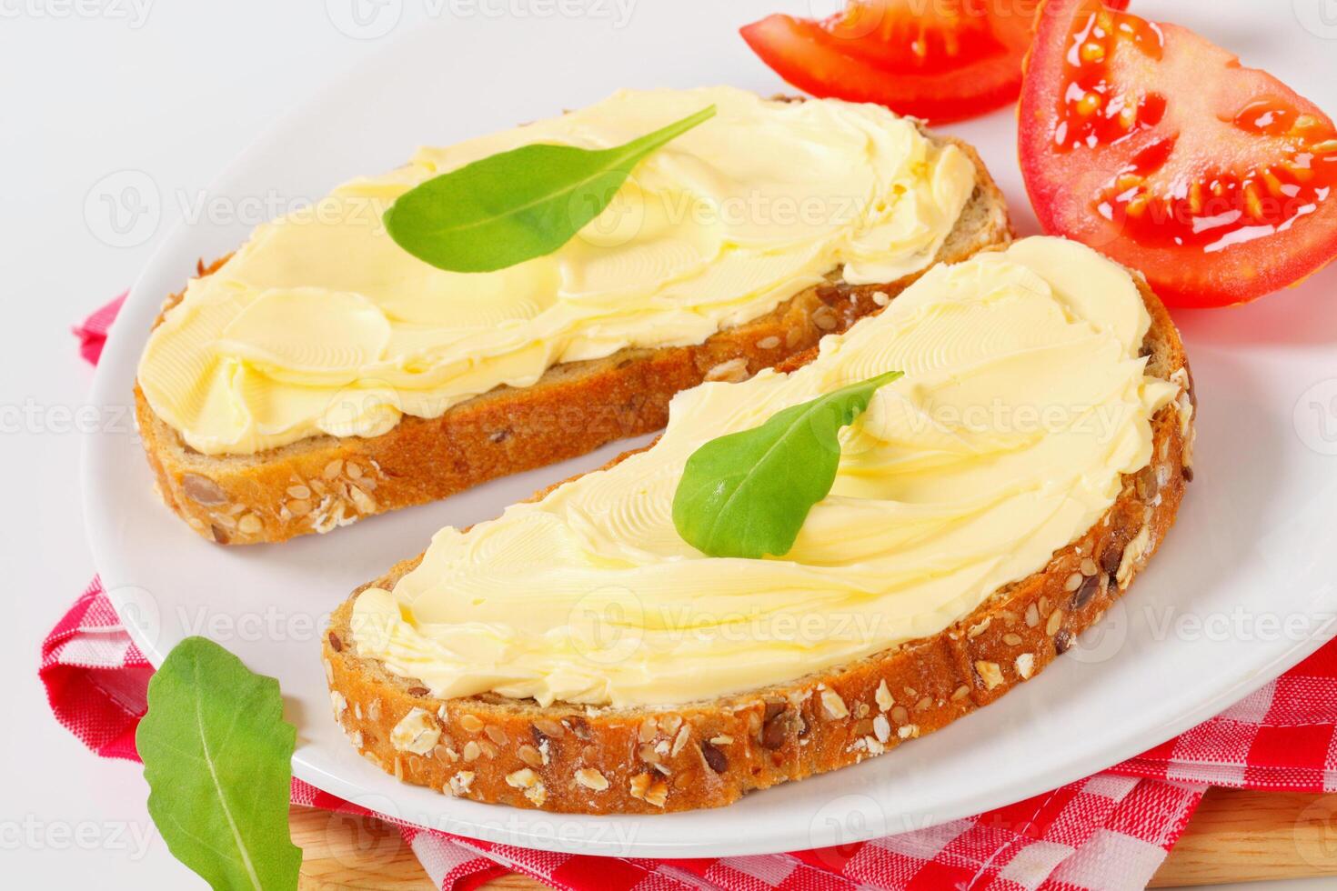 A plate topped with two slices of bread with butter photo