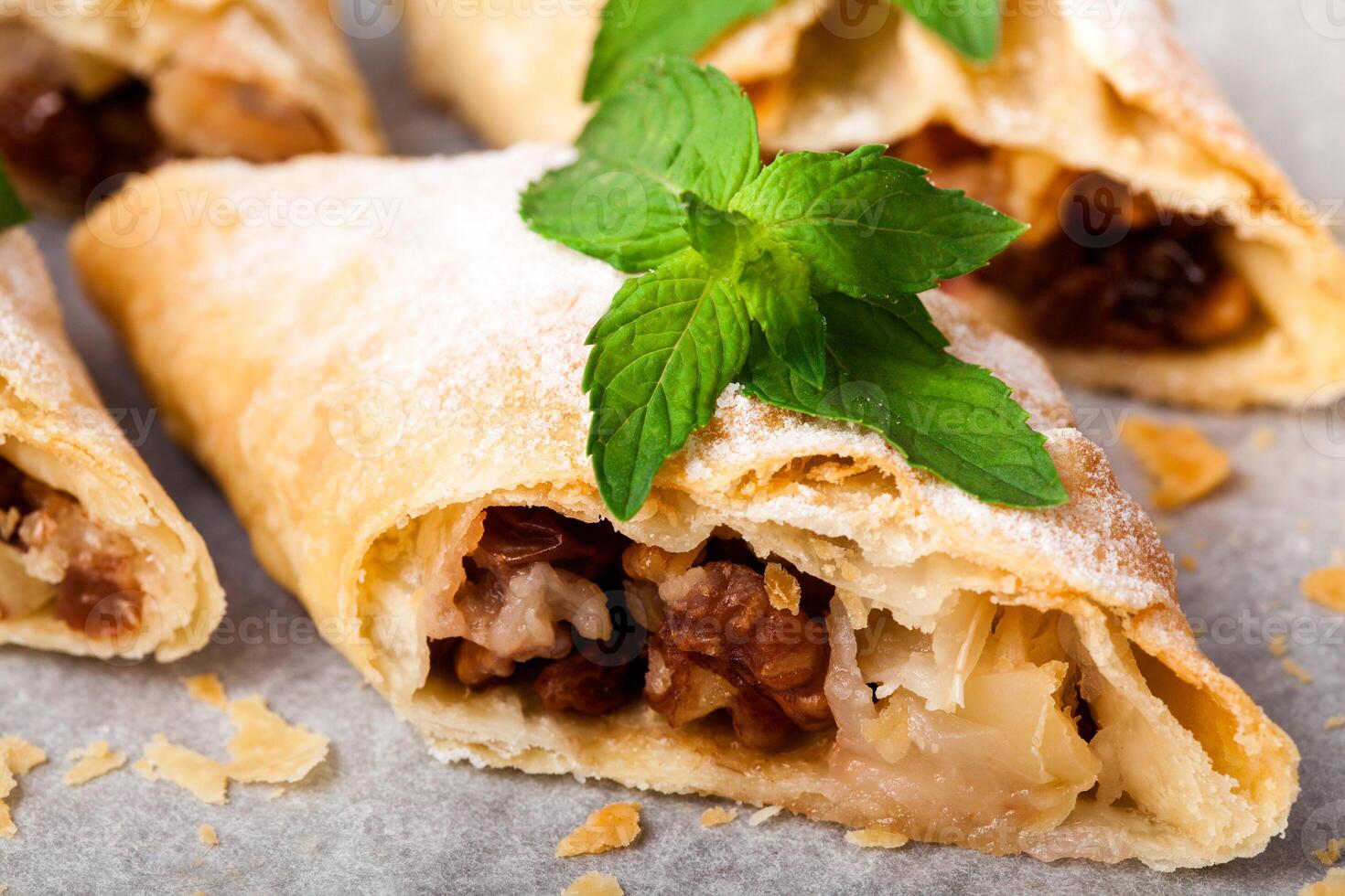 A pastry with nuts and mint leaves on top photo