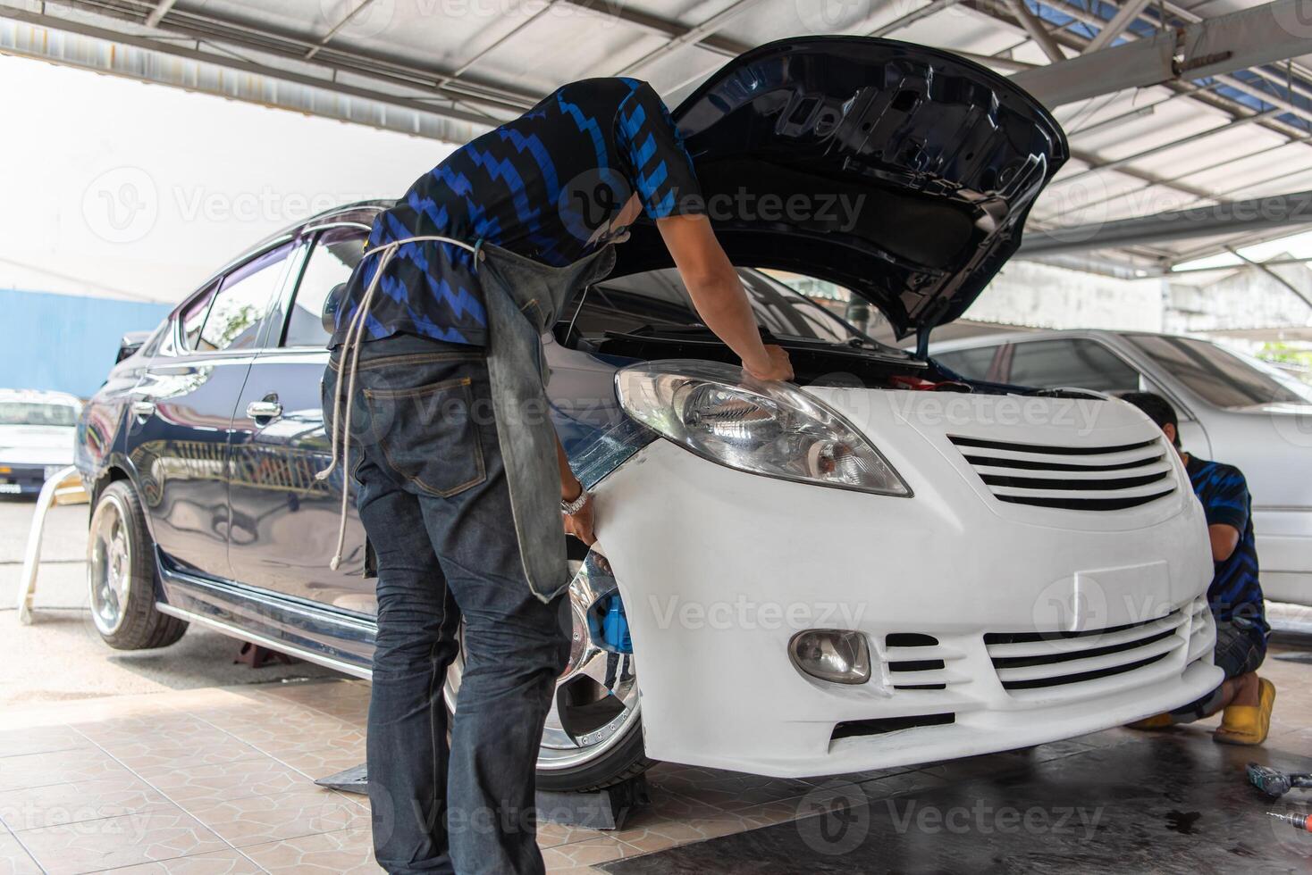 A man is working on a car photo