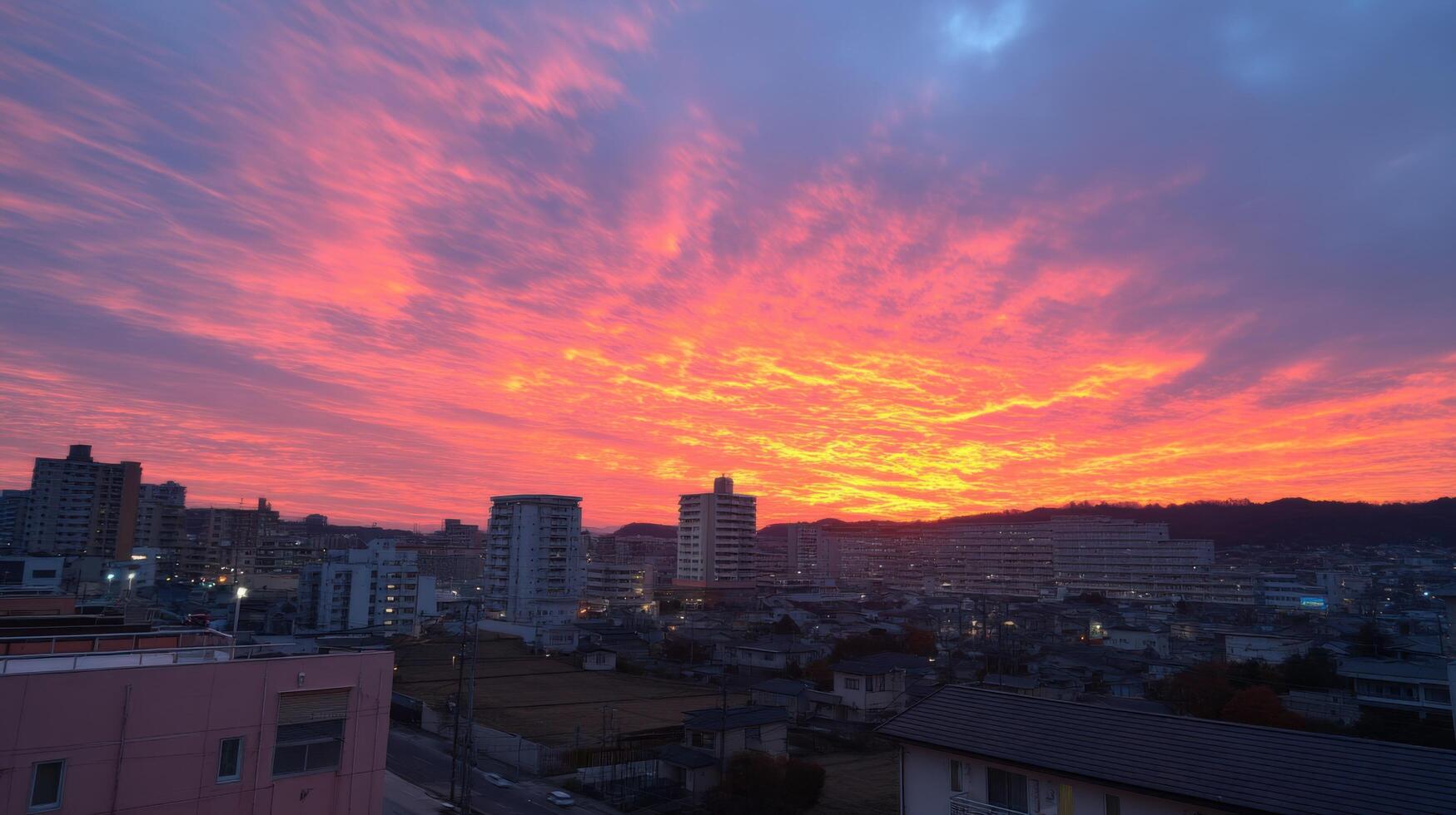 Fiery City Sunrise A breathtaking panorama of urban cityscape at dawn, painted in vibrant hues of orange, pink, and red, as the sun rises over the horizon. photo