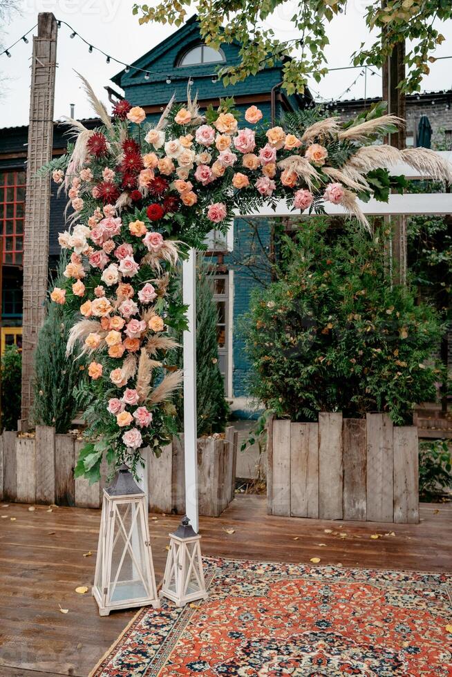 Elegant outdoor wedding floral arch with roses in natural setting photo