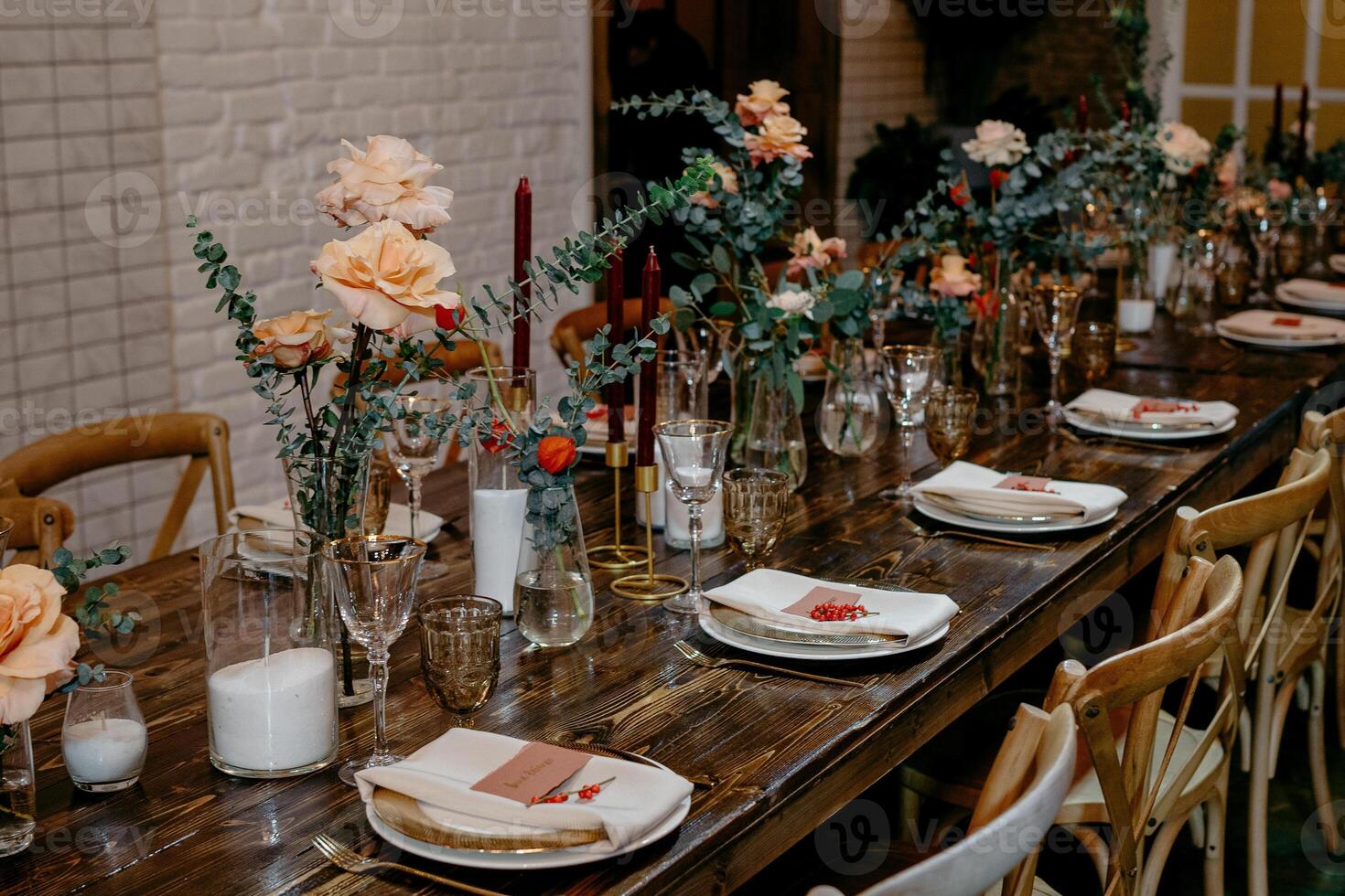 Elegant wedding table setting with floral centerpieces and candles on wooden table photo