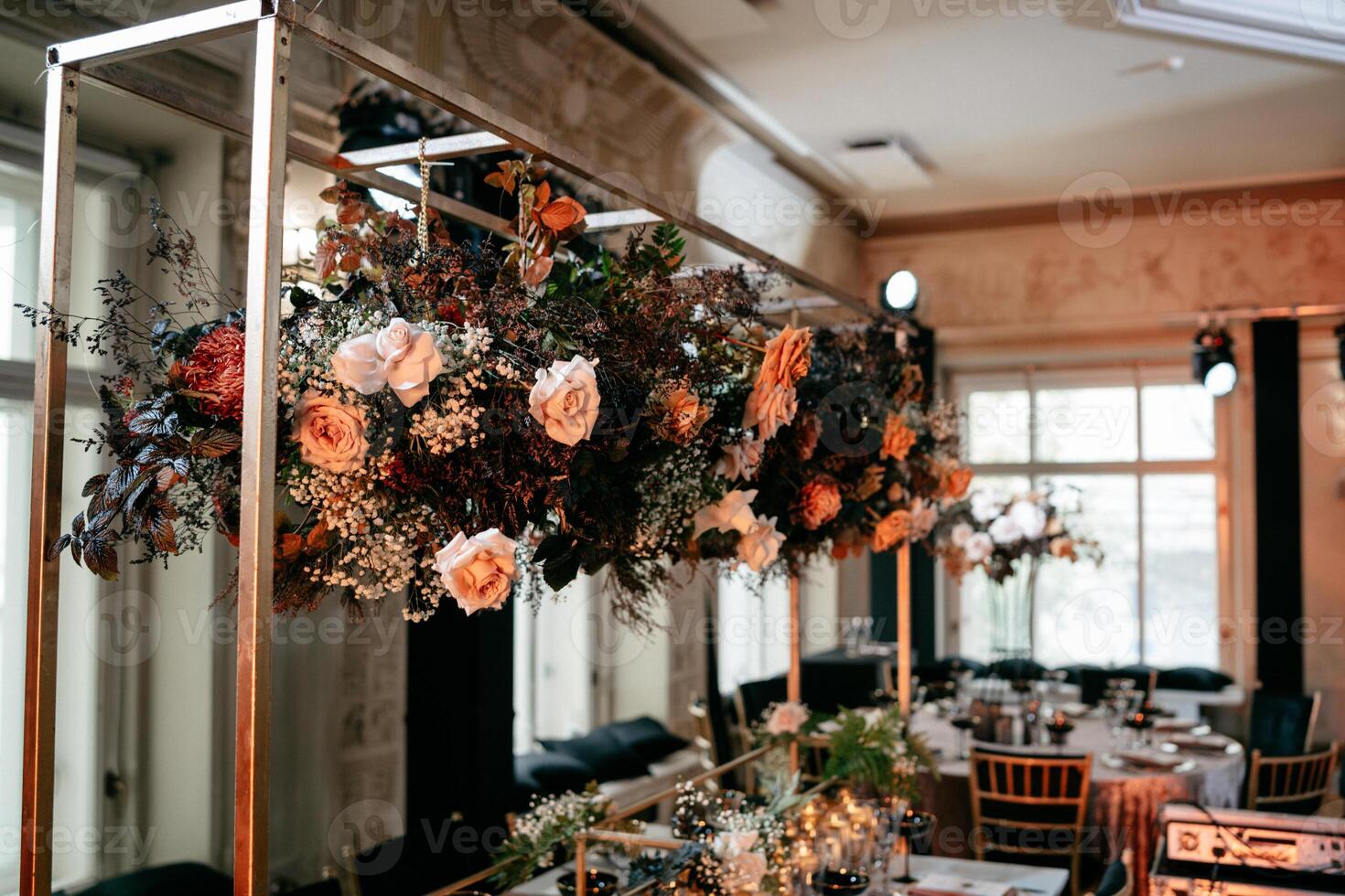 Elegant floral centerpiece in sophisticated banquet hall with luxurious decor and soft lighting ambiance photo