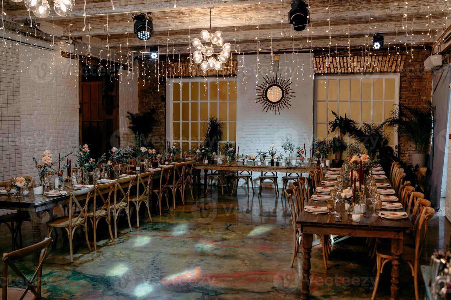 Elegant rustic wedding venue with long tables and warm lighting photo