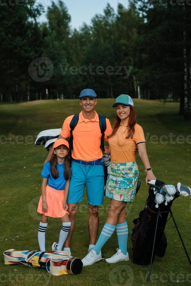 Portrait of an active family in colorful golf clothes on a summer day. Family on the golf course photo