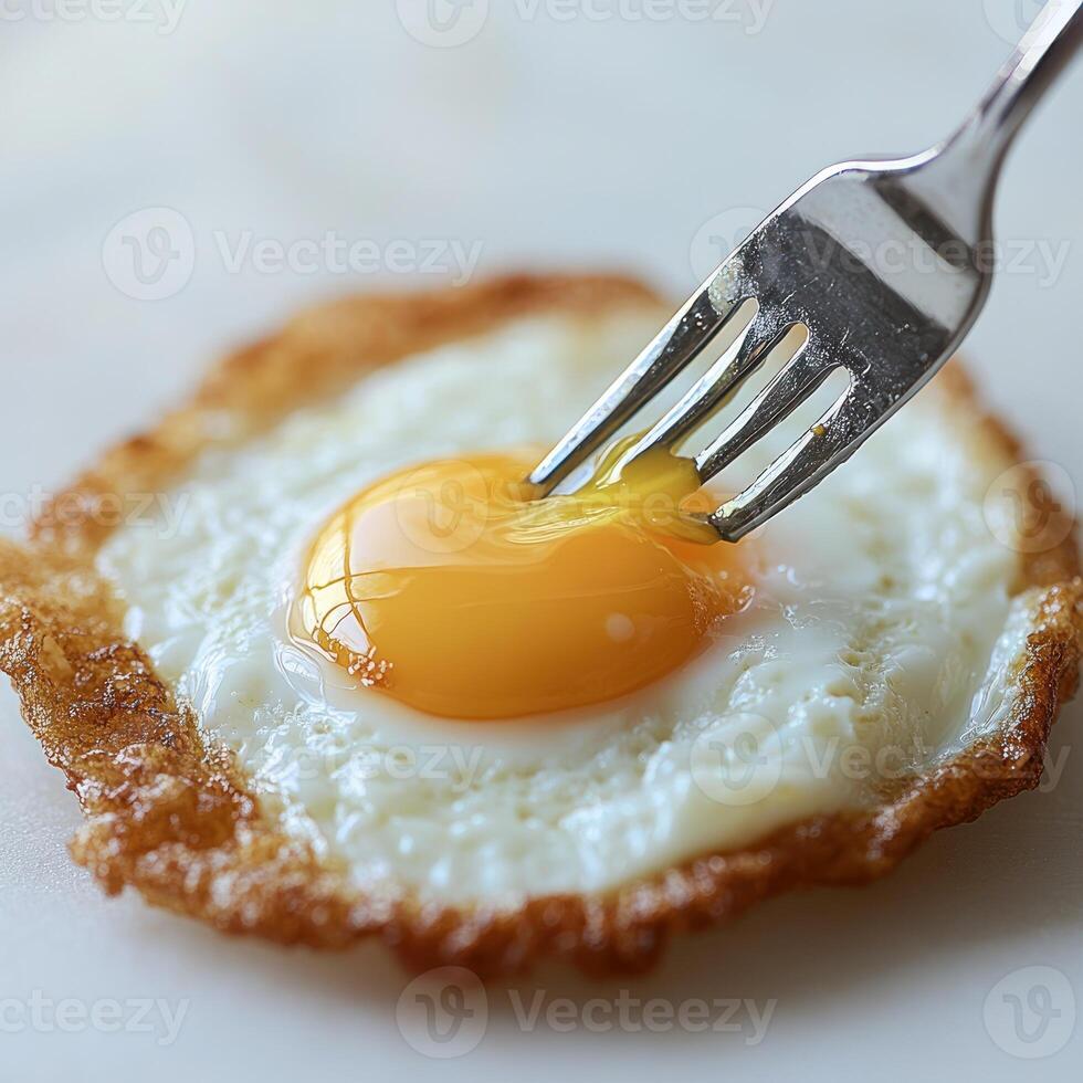 Crispy fried egg with a perfectly runny yolk on a white plate at breakfast time photo