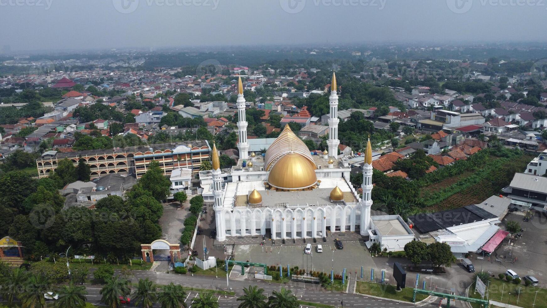 An aerial view of a white mosque with gold domes photo