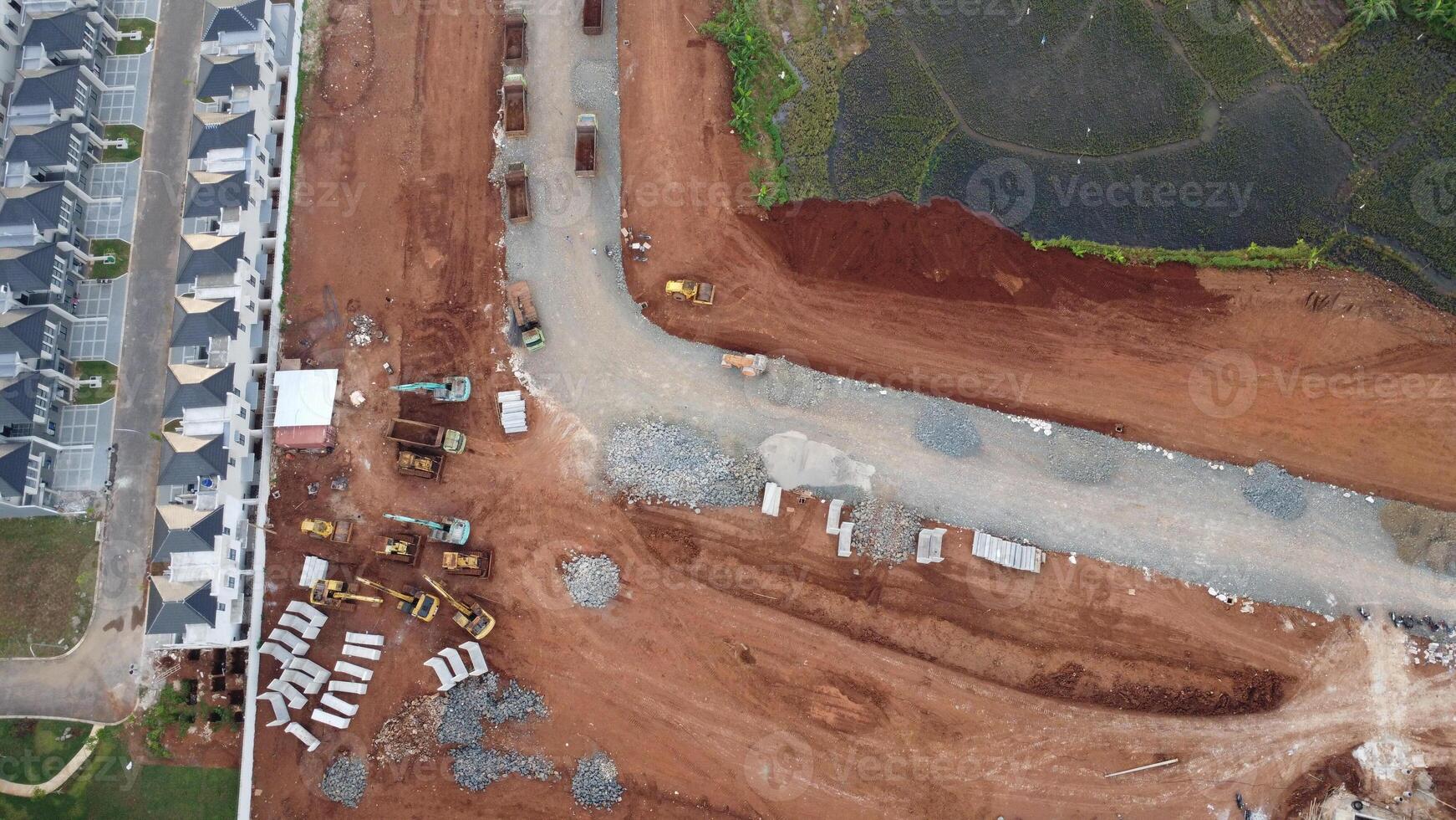 An aerial view of a construction site with a road and houses photo