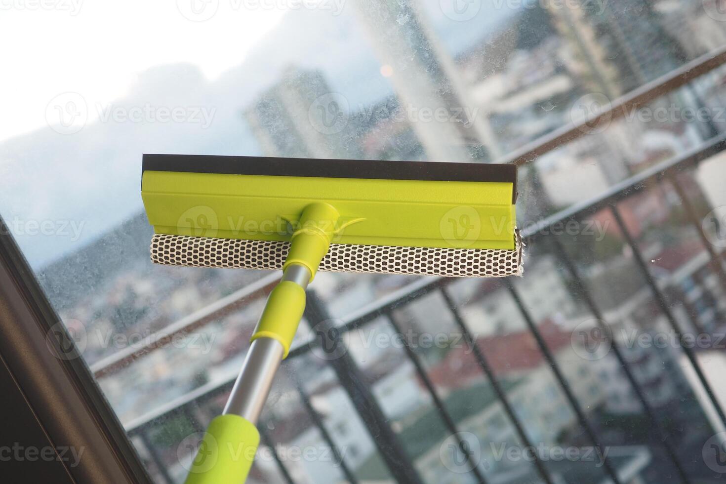 Cleaning windows from a high-rise balcony in the city photo