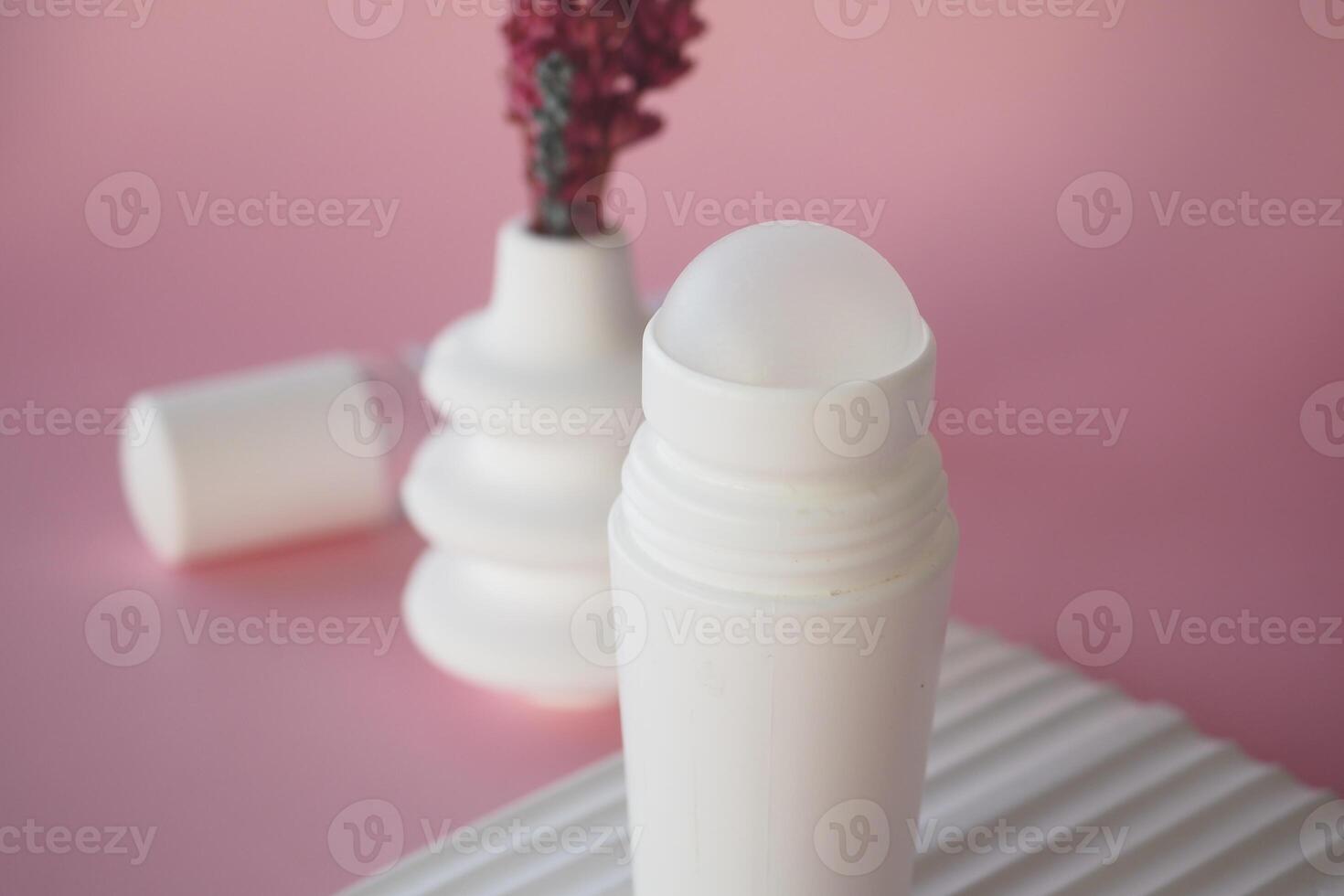 Minimalist Deodorant Bottle on Textured Surface with Soft Pink Background photo