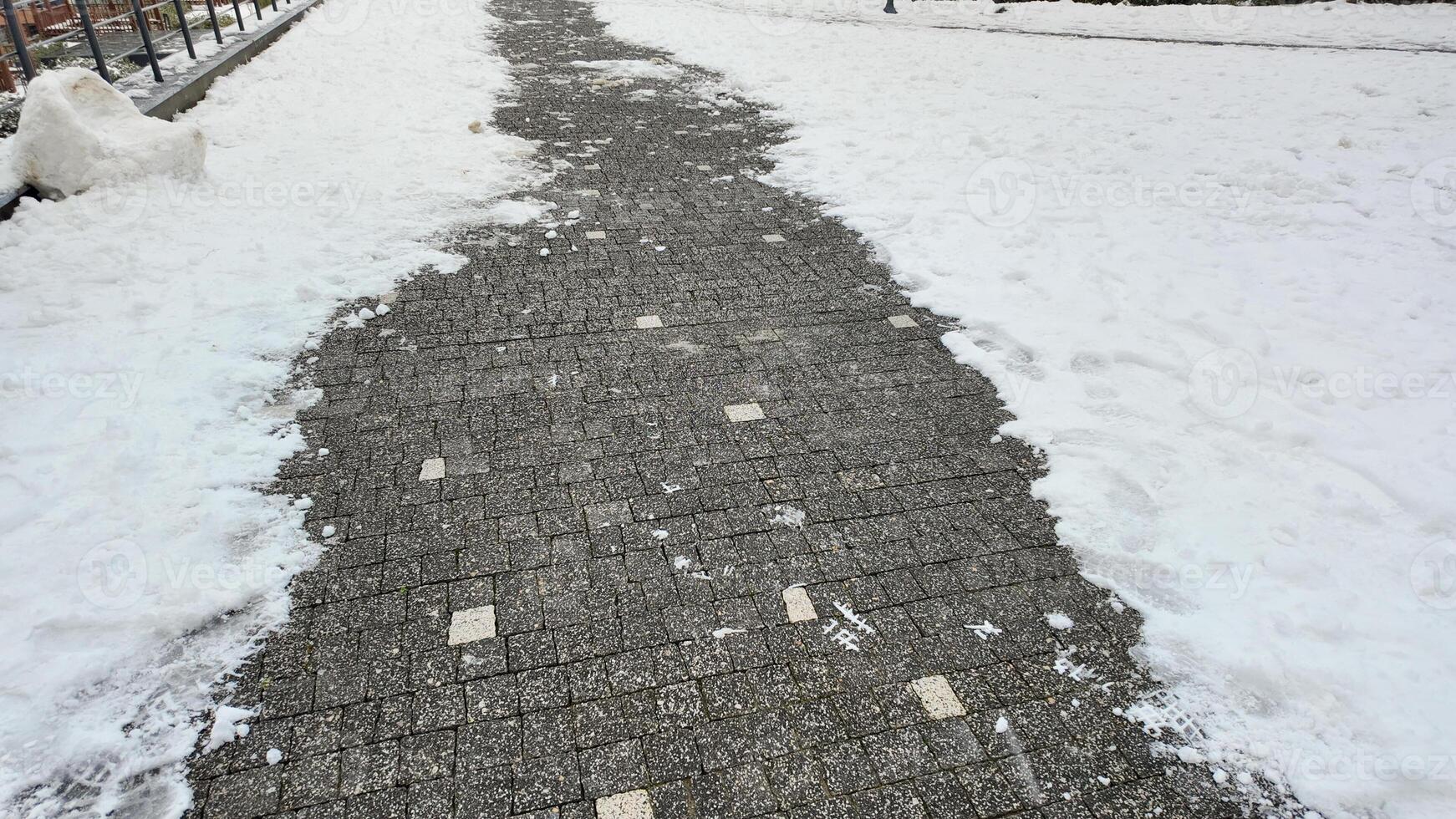 Snow covered pathway leads through a winter landscape photo