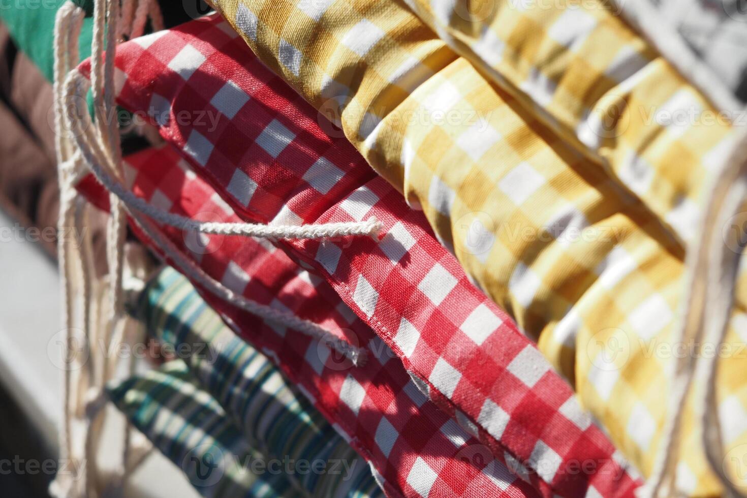 Colorful cushions displayed at a market stall in daylight photo