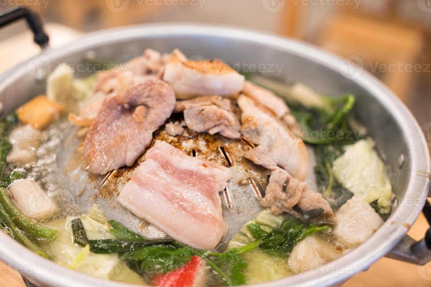 Sizzling hot Mookata, Thai BBQ grill pork on circle hot pan. photo