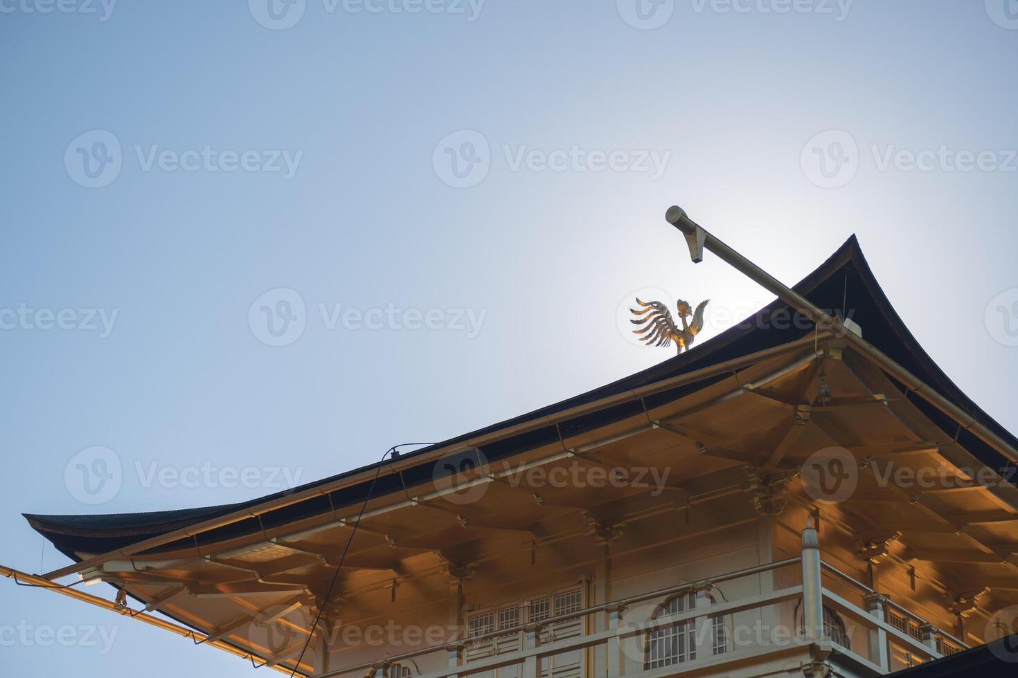 Kinkaku-ji Golden Pavilion Temple in Kyoto Japan, Traditional pagoda roof against a clear blue sky. photo
