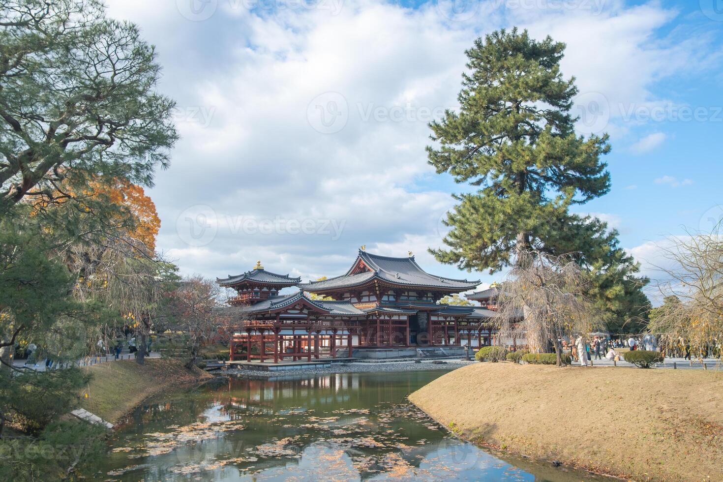 Byodo-in Temple Uji Kyoto Japan, Traditional architecture beside a serene pond under a cloudy sky. photo