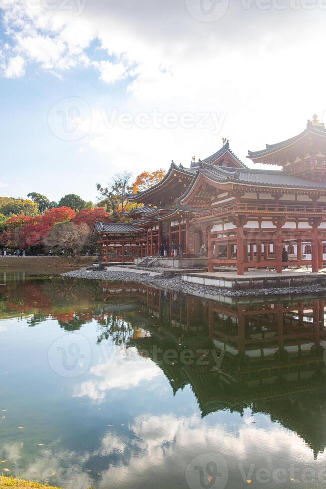 Byodo-in Temple Uji Kyoto Japan, Traditional temple reflected in serene water under a cloudy sky. photo