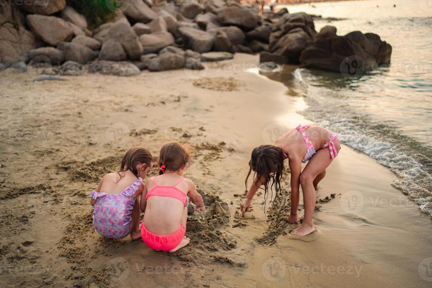 Family fun on the beach at sunset as kids build sandcastles photo