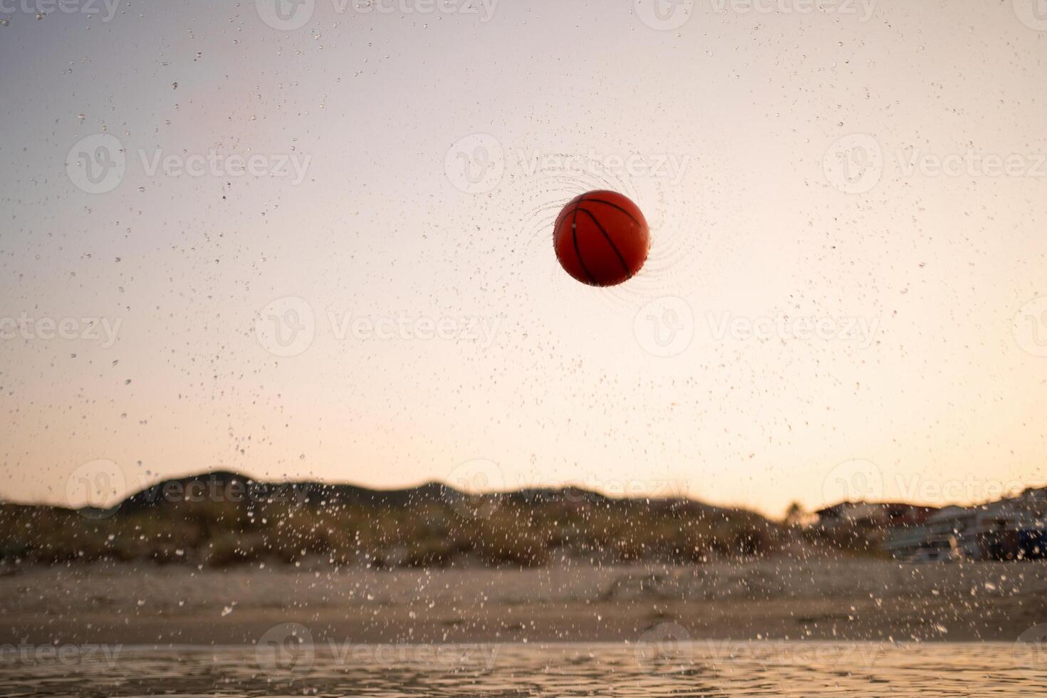 Family enjoys an adventurous game of basketball by the beach at sunset photo