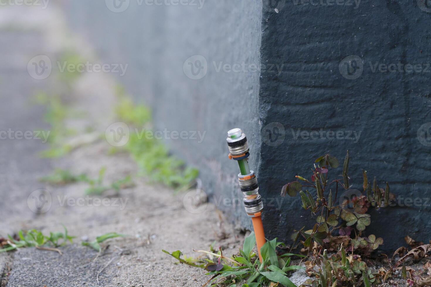 Fiber optic connection was installed between the footpath at paving stones and the housewall photo