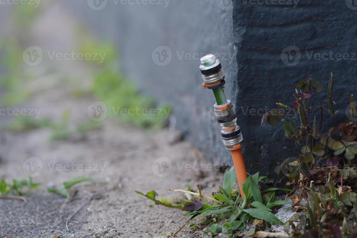 Fiber optic connections were installed between the footpath at paving stones and the house wall photo