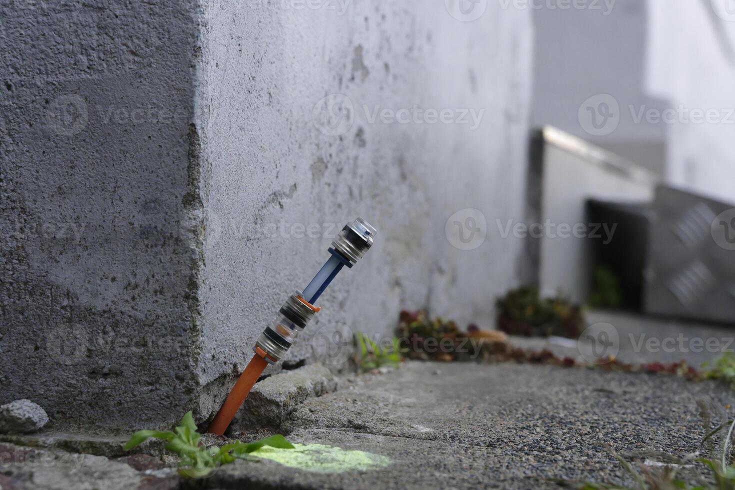 Fiber optic connection is installed between the footpath at paving stones and the house wall photo