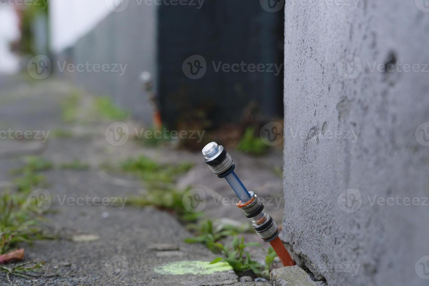 Fiberoptic connection was installed between the footpath at paving stones and the house wall photo