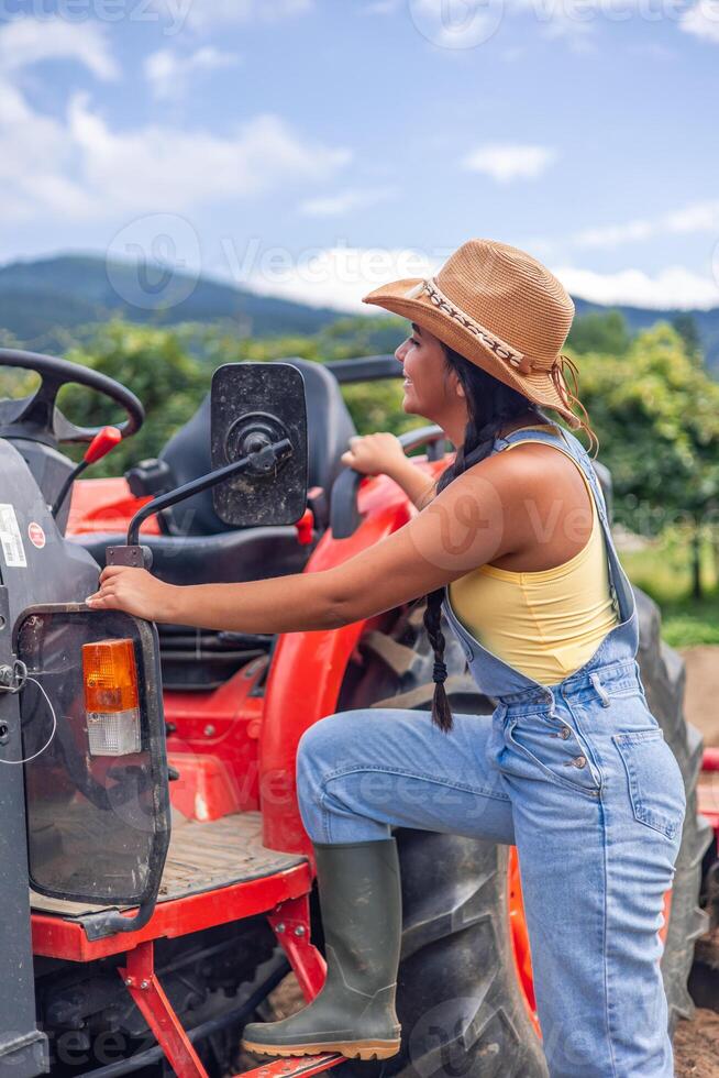 vertical Latin american farmer woman getting on her tractor in a sunny day photo